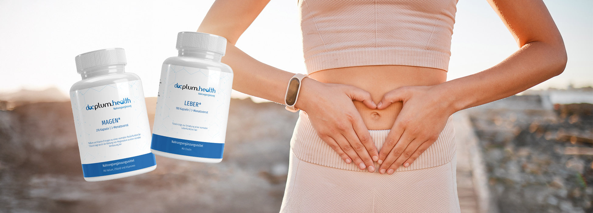 Person formt mit den Händen ein Herz vor dem Bauch, daneben sind zwei Nahrungsergänzungsmittel-Dosen zu sehen.