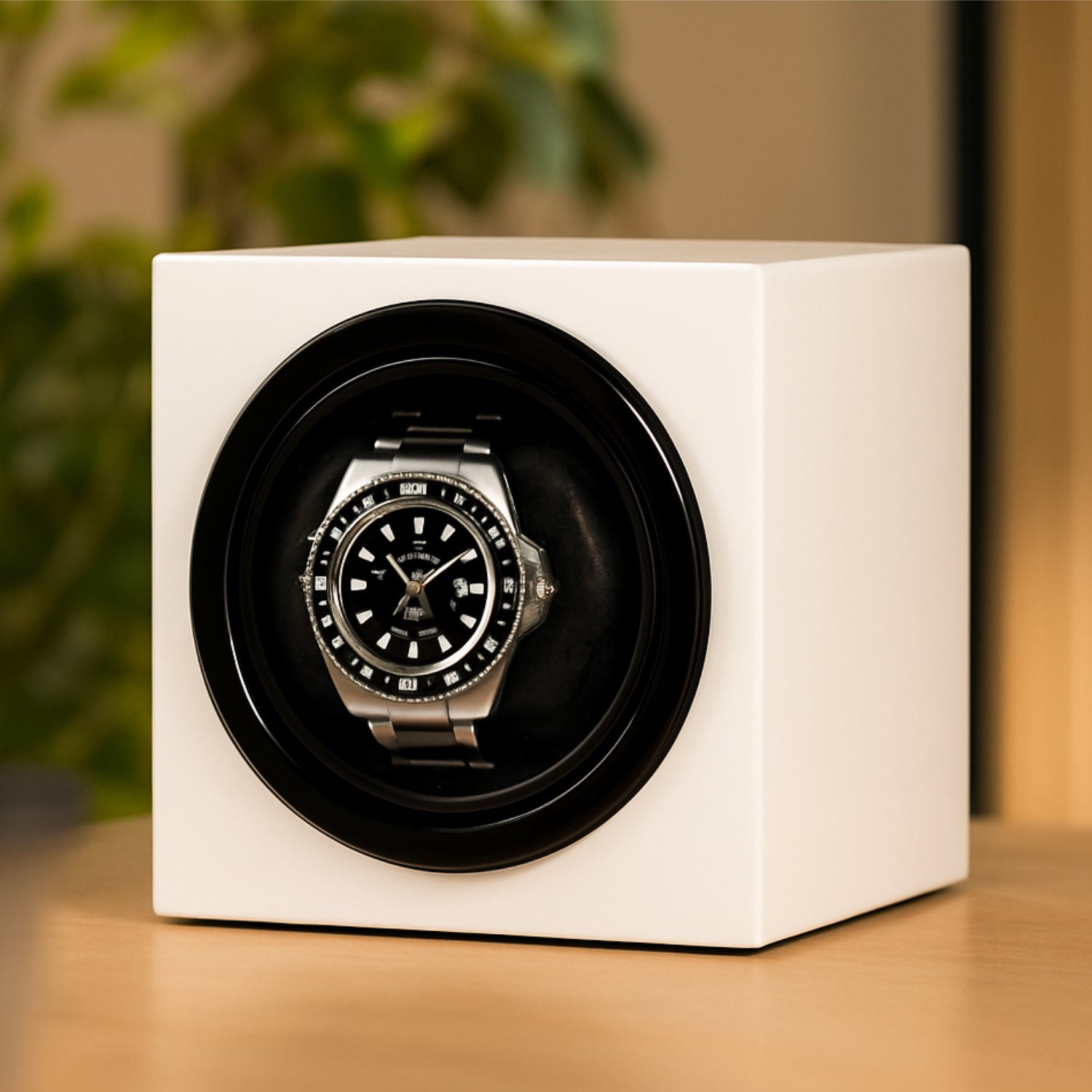 Silberne Armbanduhr mit schwarzem Zifferblatt in einer weißen Uhrenbox, auf einem Holztisch stehend.