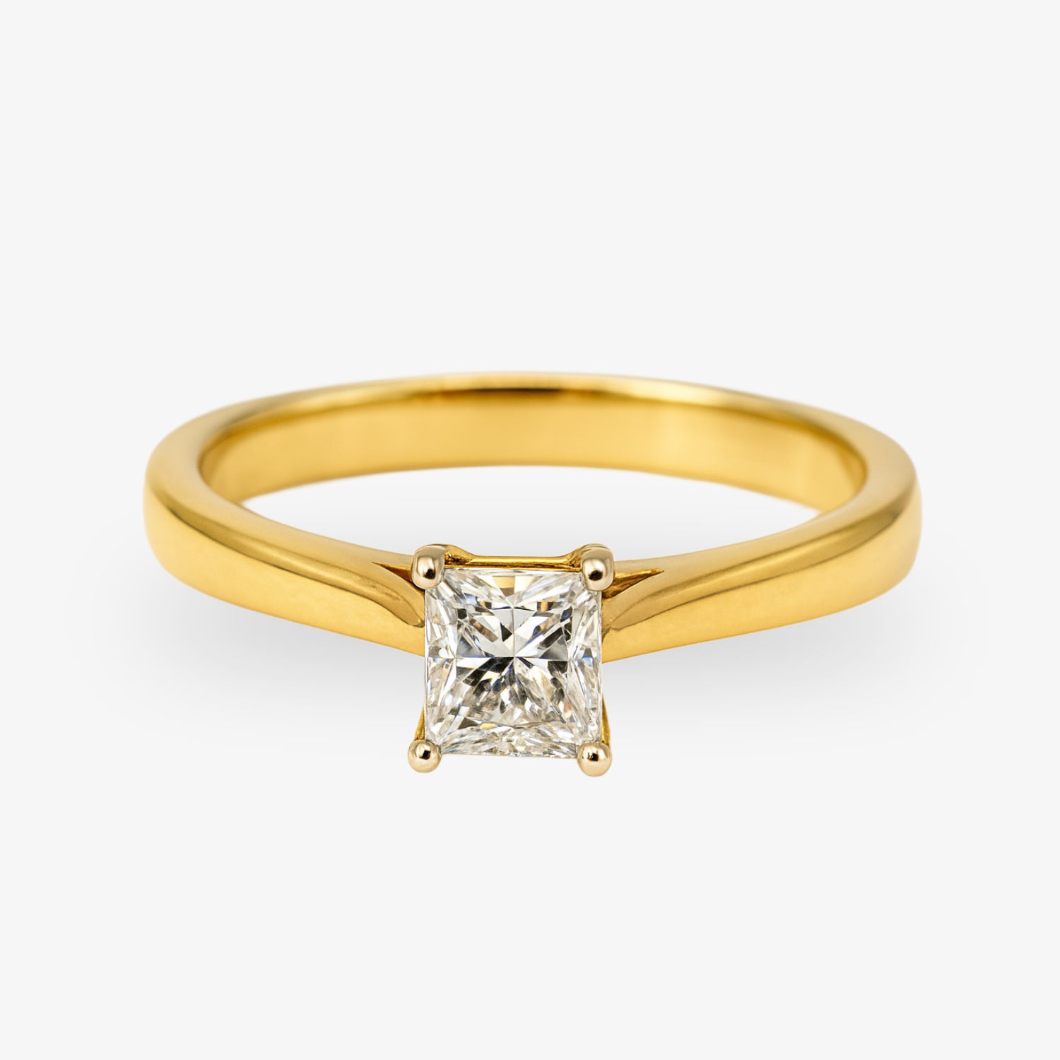 Goldener Ring mit einem quadratischen Diamanten in einer Krallenfassung auf weißem Hintergrund.