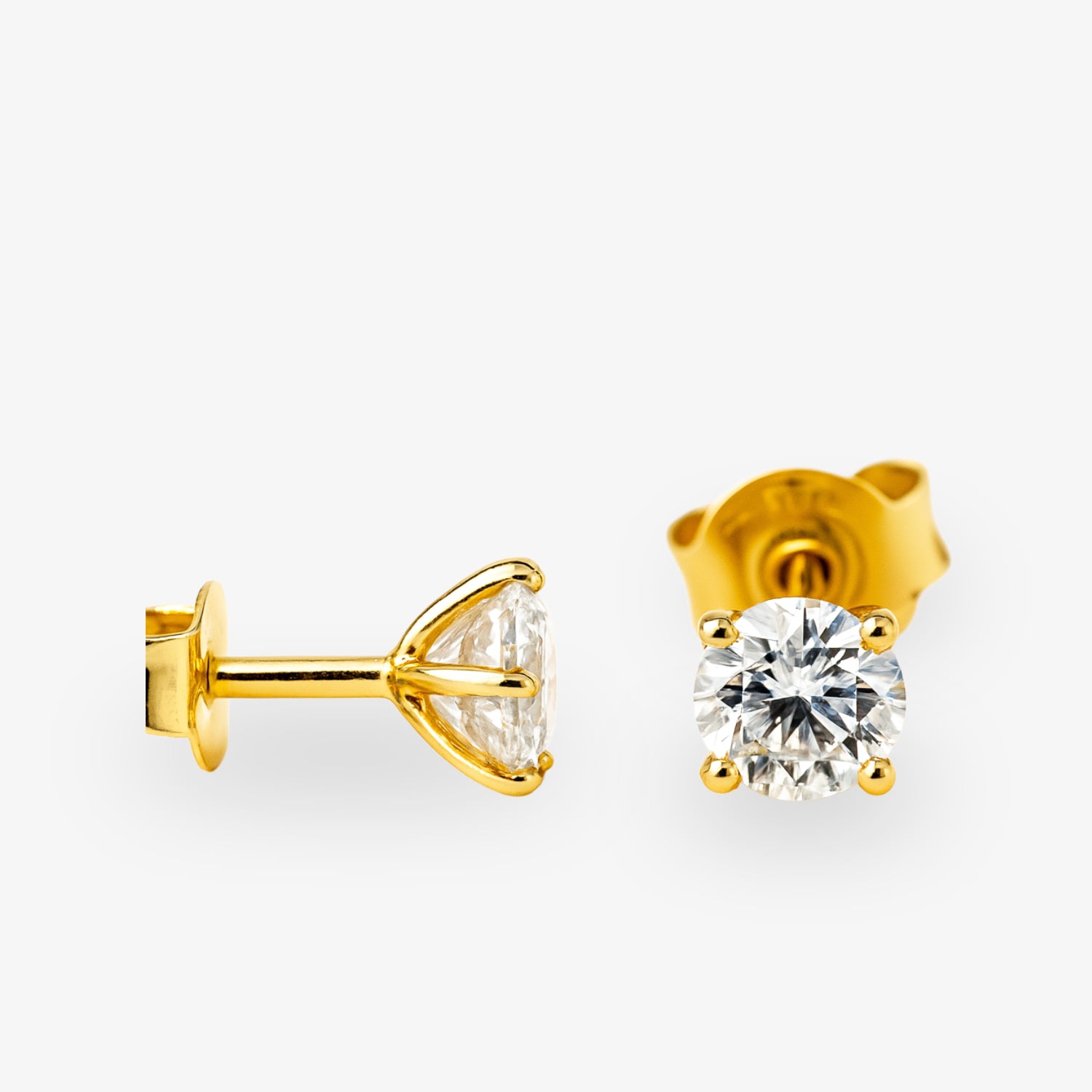 Goldene Ohrstecker mit funkelnden Diamanten auf weißem Hintergrund.