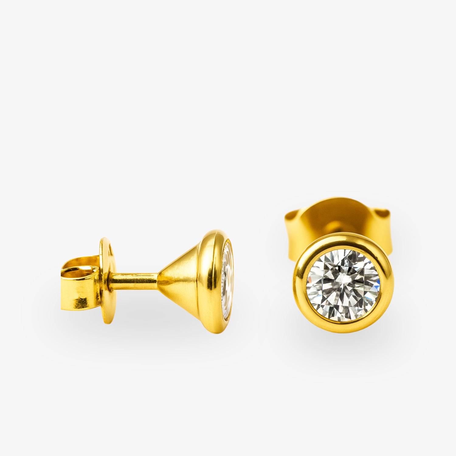 Zwei goldene Ohrstecker mit runden klaren Diamanten auf weißem Hintergrund.