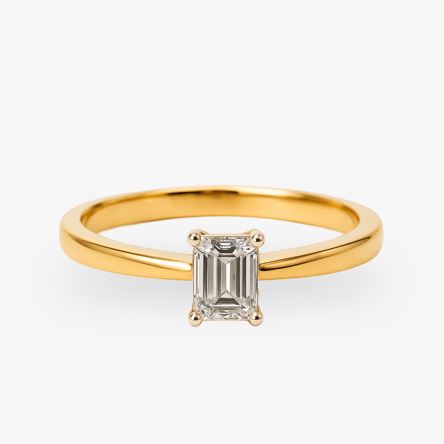 Goldener Ring mit rechteckigem Diamanten auf weißem Hintergrund.