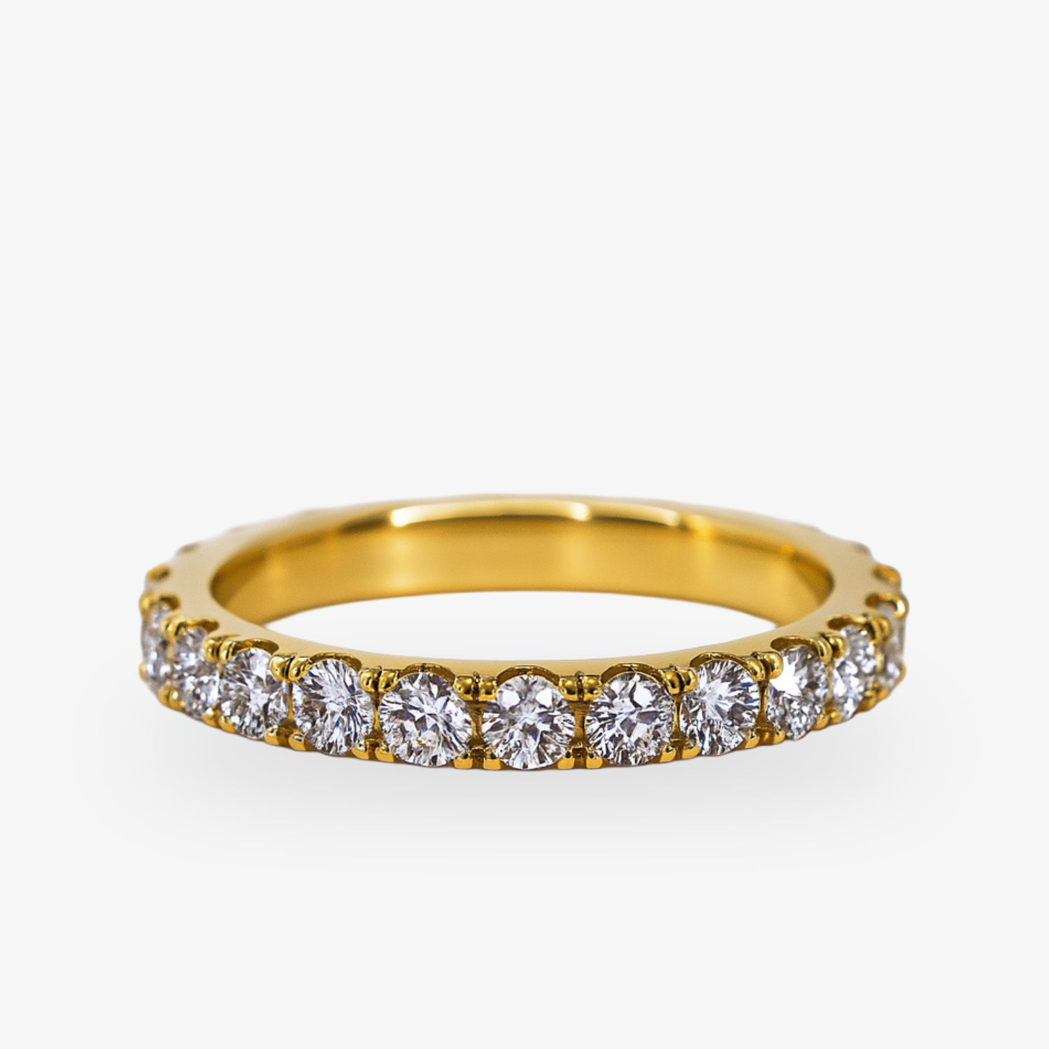 Goldener Ring mit rundum eingefassten Diamanten auf weißem Hintergrund.