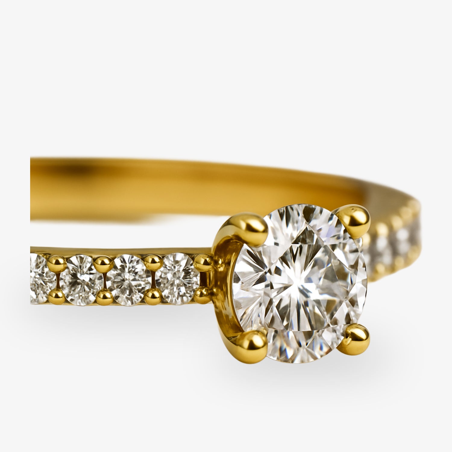 Nahaufnahme eines goldenen Rings mit einem großen, funkelnden Diamanten und mehreren kleinen Diamanten an der Schiene.