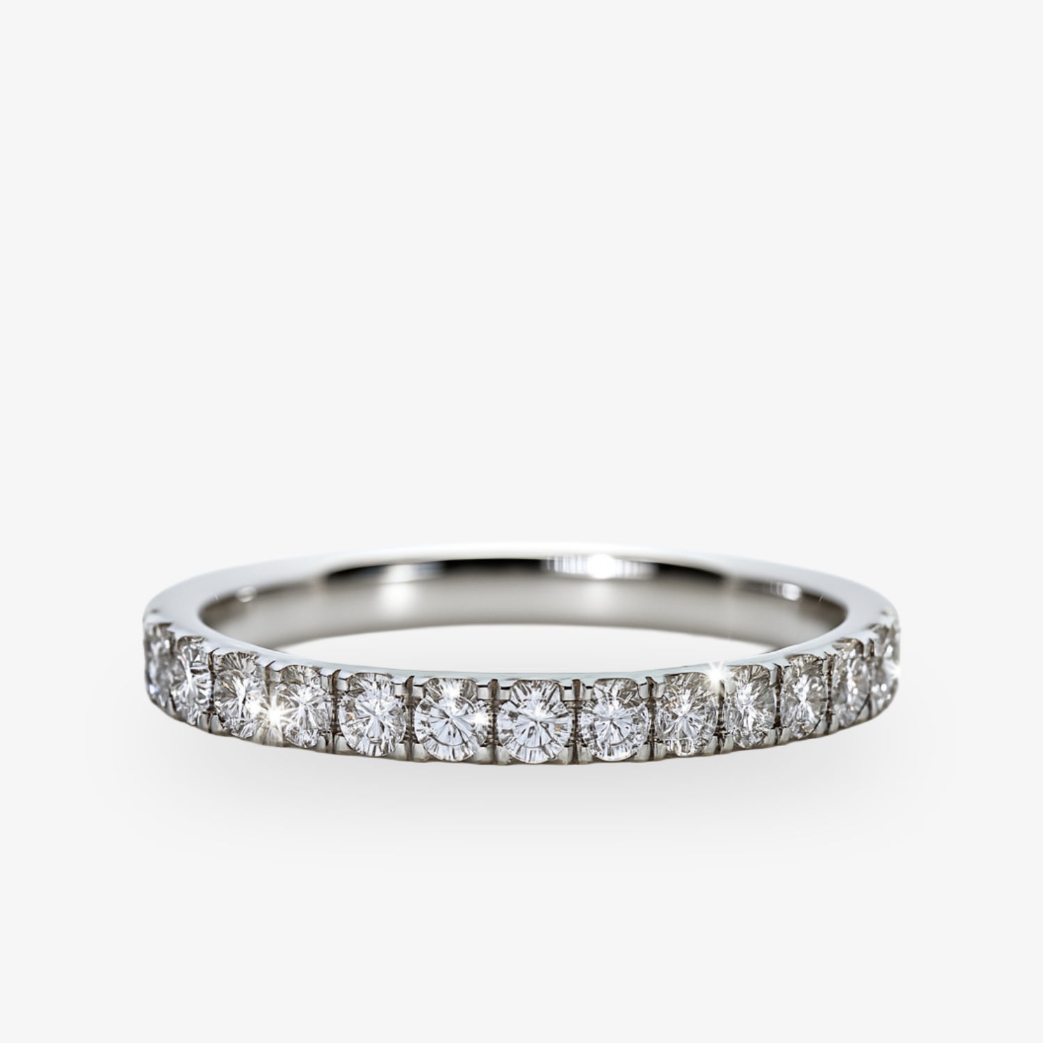 Silberner Ring mit mehreren kleinen Diamanten, gleichmäßig um den Ring verteilt, auf weißem Hintergrund.