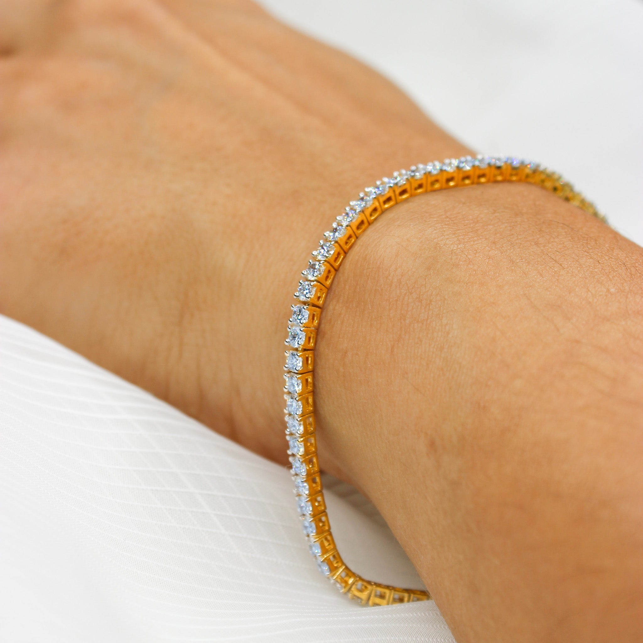 Tennisarmband aus 585er Gelbgold mit funkelnden Brillanten, elegant am Handgelenk getragen.