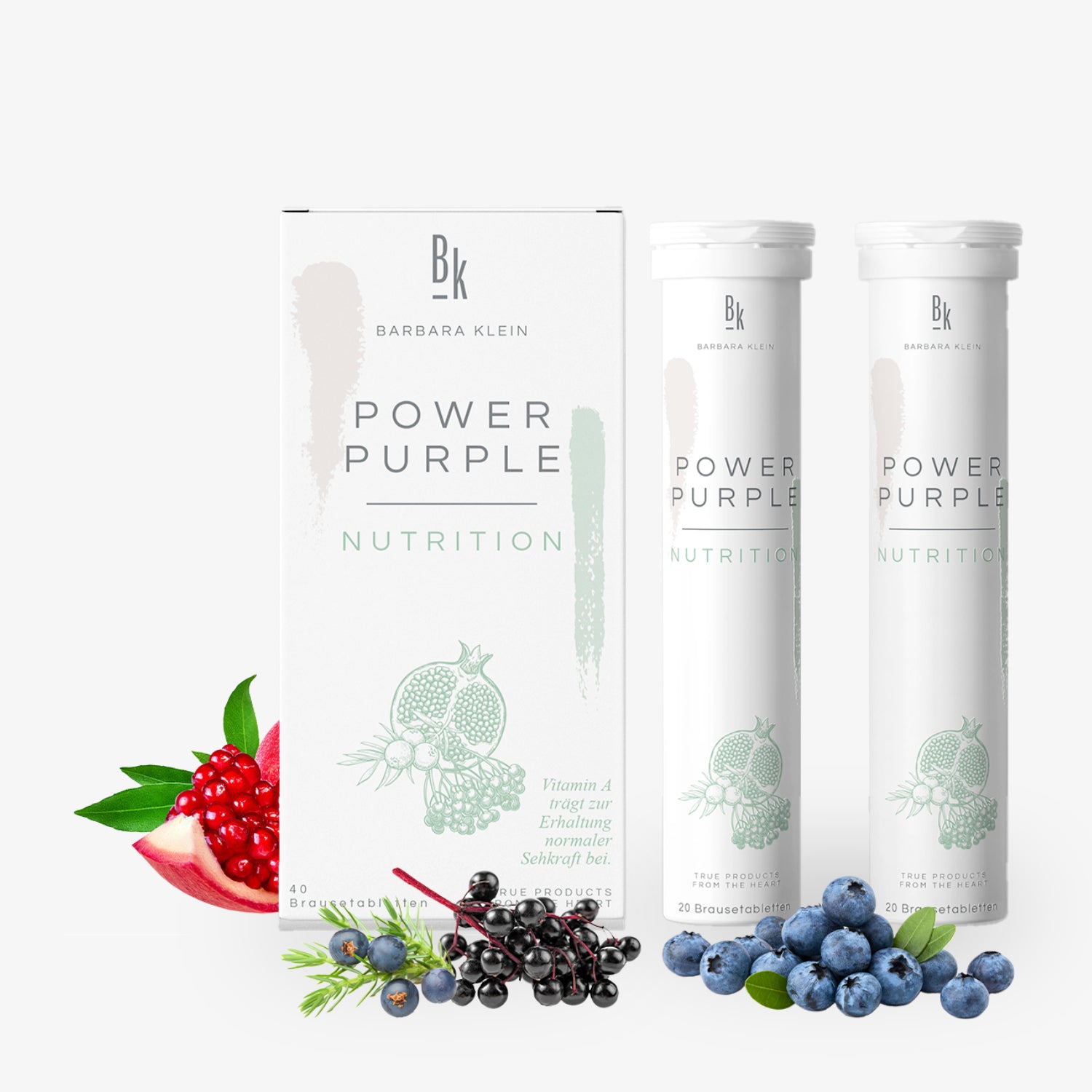 Verpackung und zwei Röhren mit der Aufschrift "Power Purple Nutrition", umgeben von Beeren und Granatapfel.