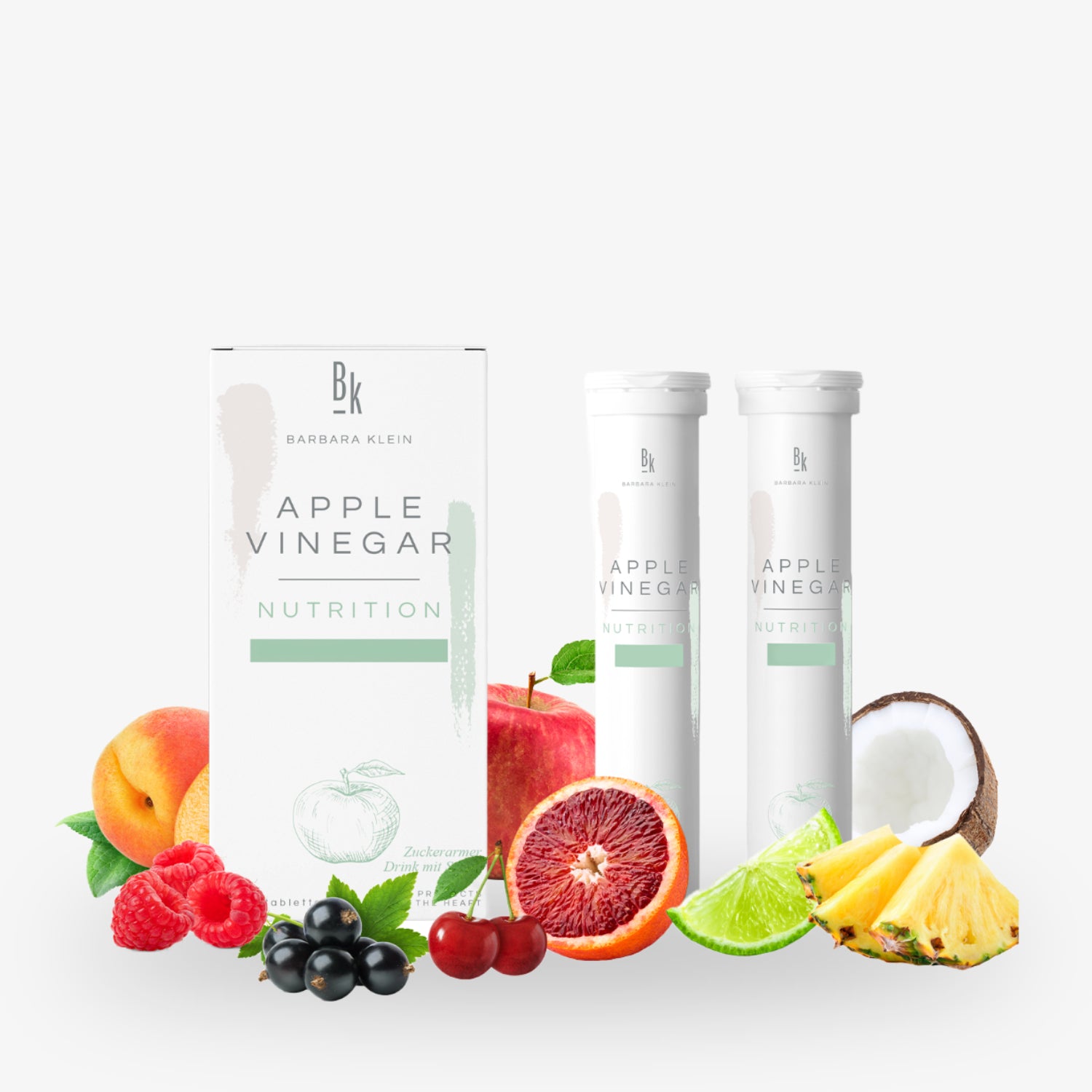 Verpackung von Apfelessig-Tabletten umgeben von verschiedenen Früchten wie Apfel, Orange, Kokosnuss und Ananas.