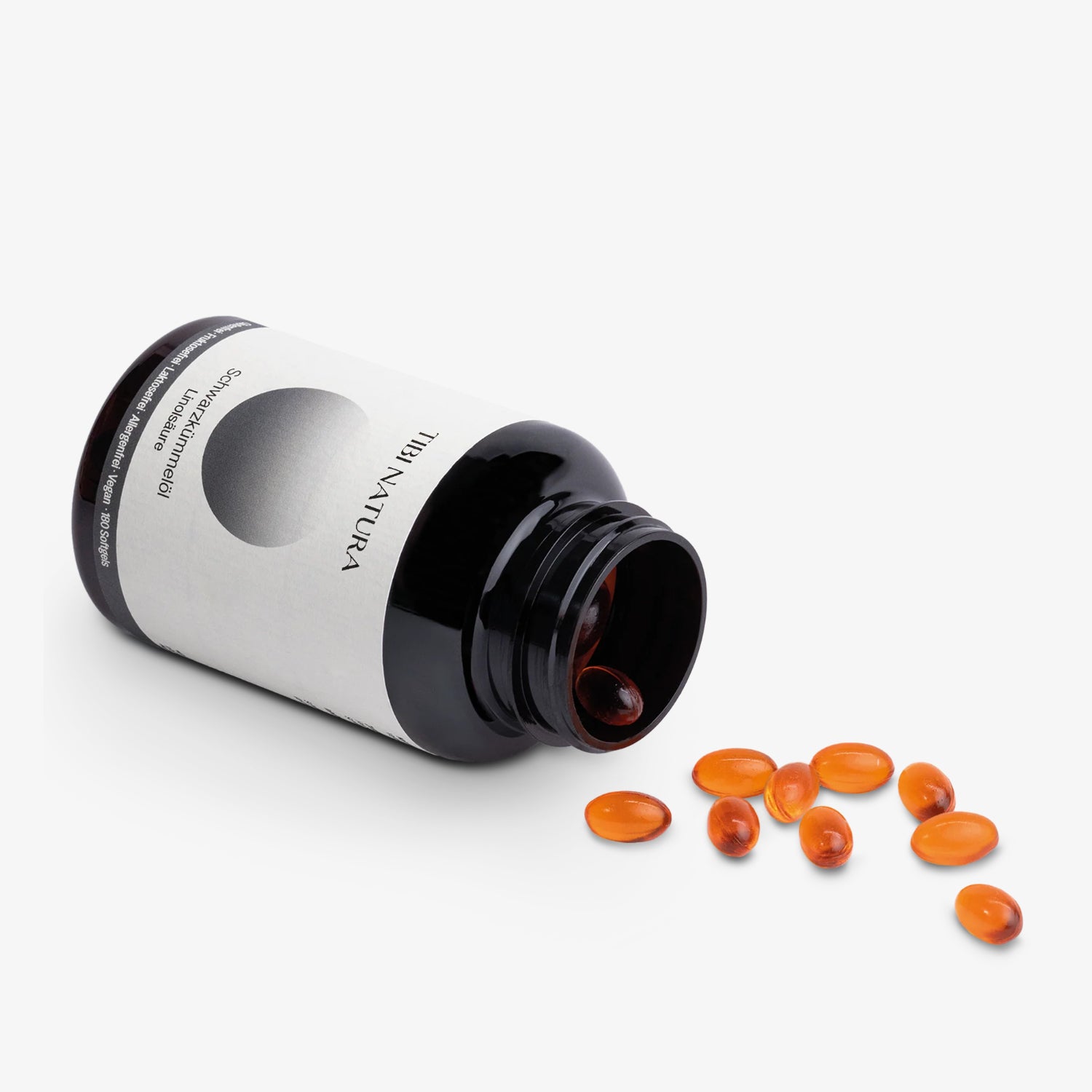 Braunes Fläschchen mit orangenen Kapseln, die auf einer Oberfläche verteilt sind.