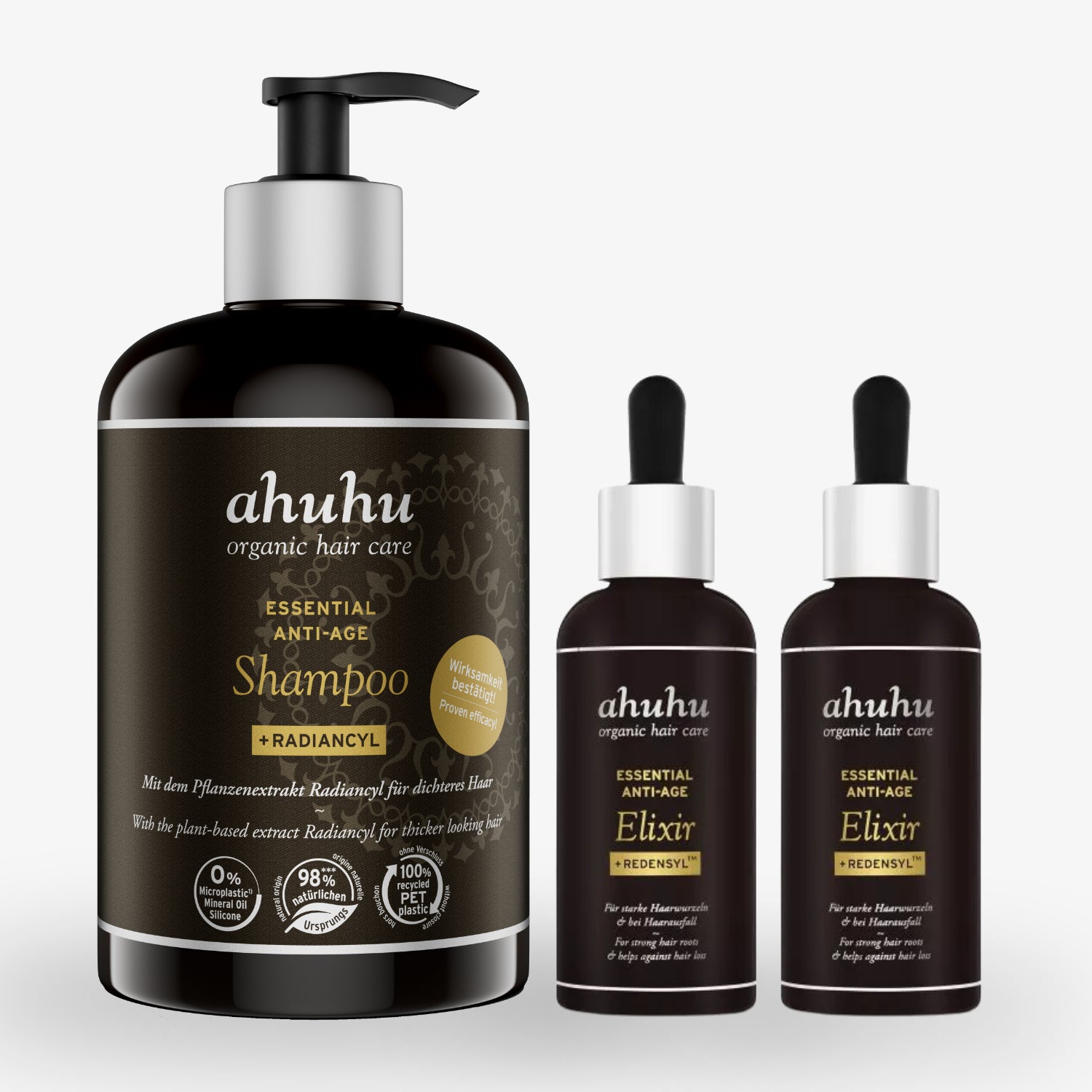 Drei Flaschen von Ahuhu Haarpflegeprodukten auf weißem Hintergrund, zwei Elixire und ein Shampoo.