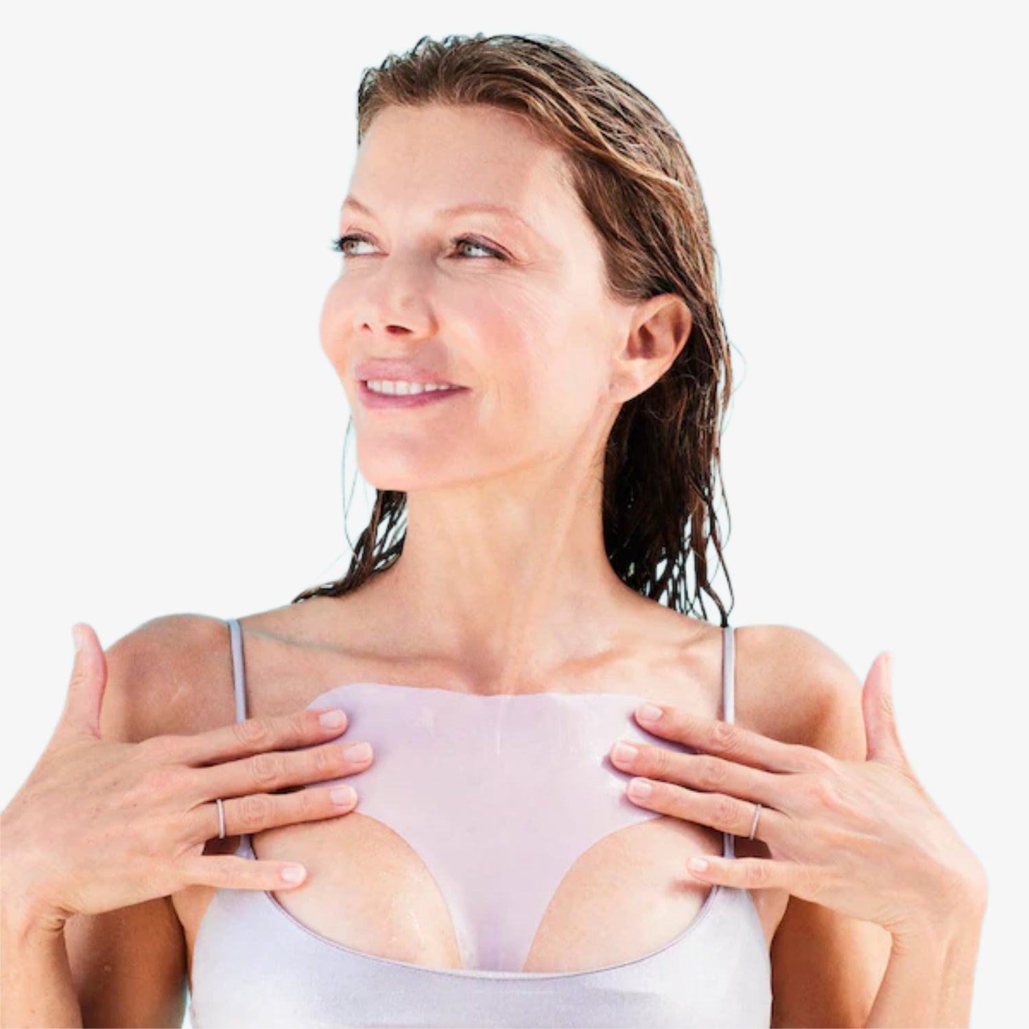 Frau mit nassen Haaren trägt ein hautfarbenes, transparentes Hautpflaster auf dem Dekolleté und lächelt leicht.