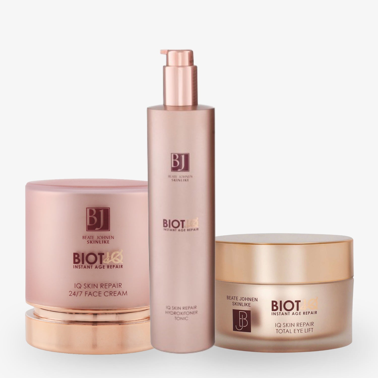 Drei Kosmetikprodukte mit rosa-goldener Verpackung von Beate Johnen, darunter Creme und Tonic, auf weißem Hintergrund.