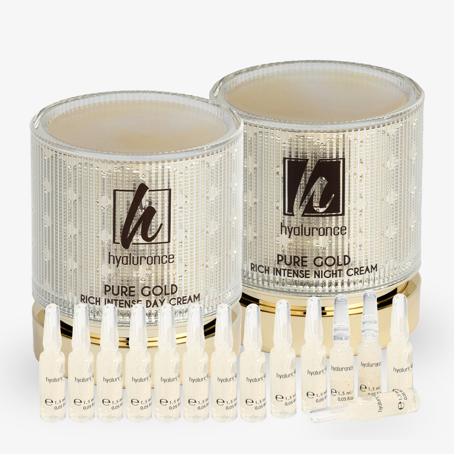 Zwei Cremetiegel mit Aufschrift "Pure Gold" und kleine Ampullen davor, auf weißem Hintergrund.