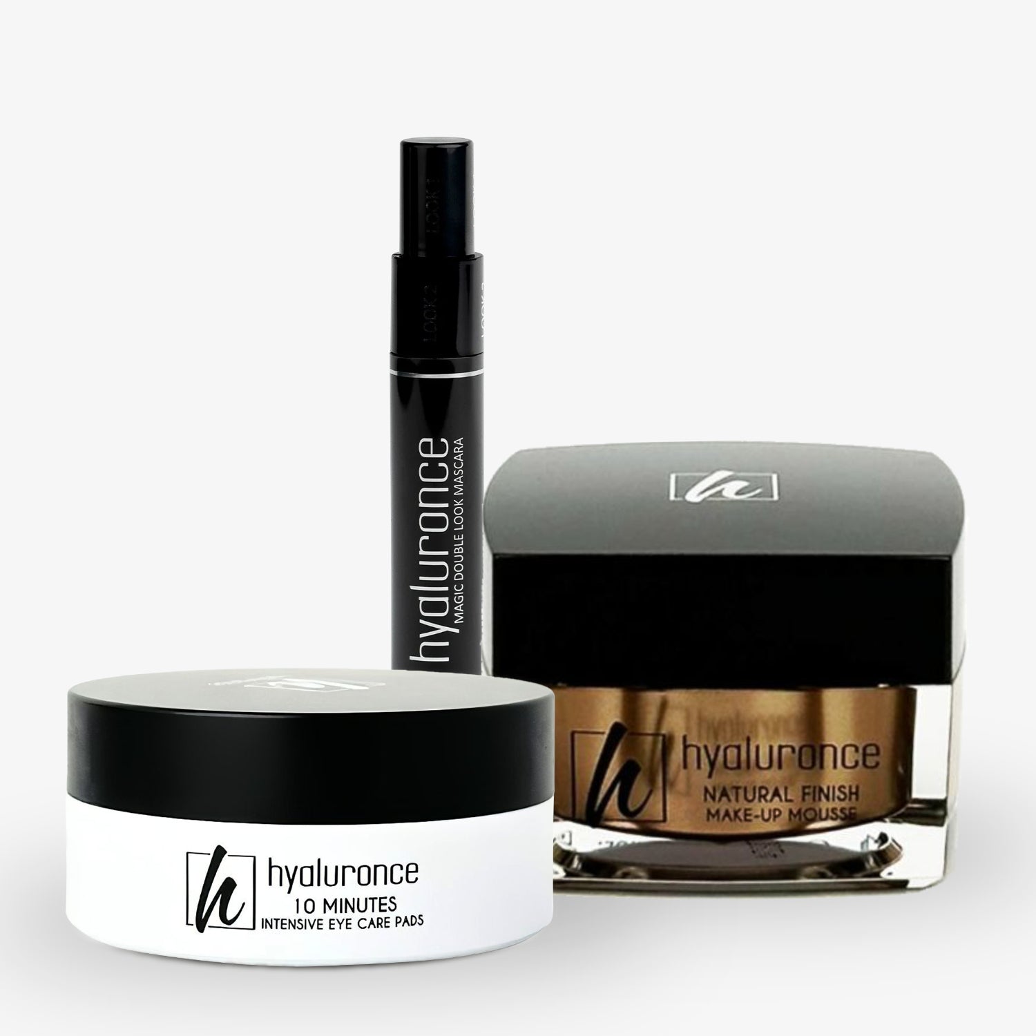 Drei Kosmetikprodukte mit der Aufschrift "hyaluronce": Eye Care Pads, Mascara und Make-up Mousse, auf hellem Hintergrund.