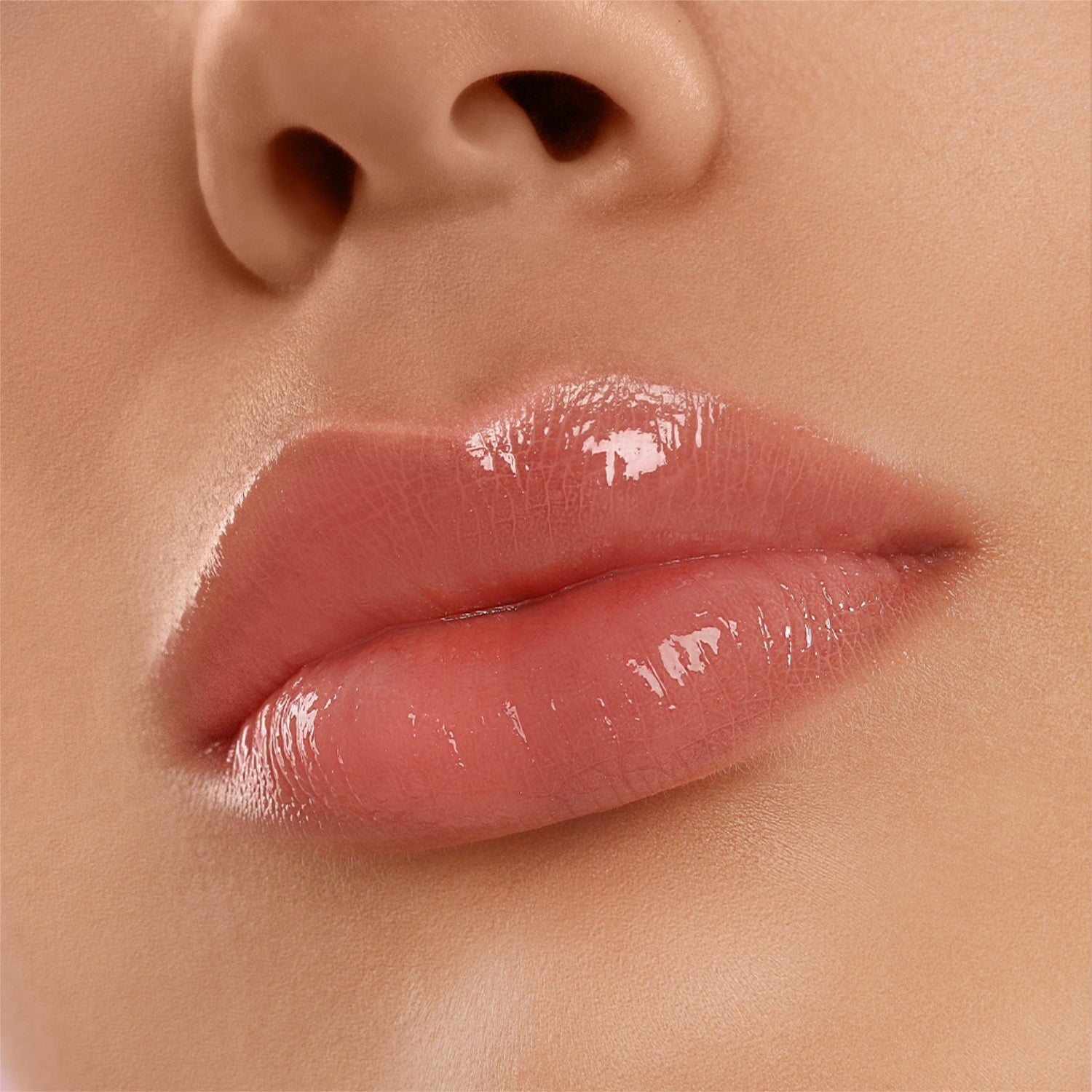 Nahaufnahme eines glänzend geschminkten Lippenpaars in einem natürlichen Farbton.