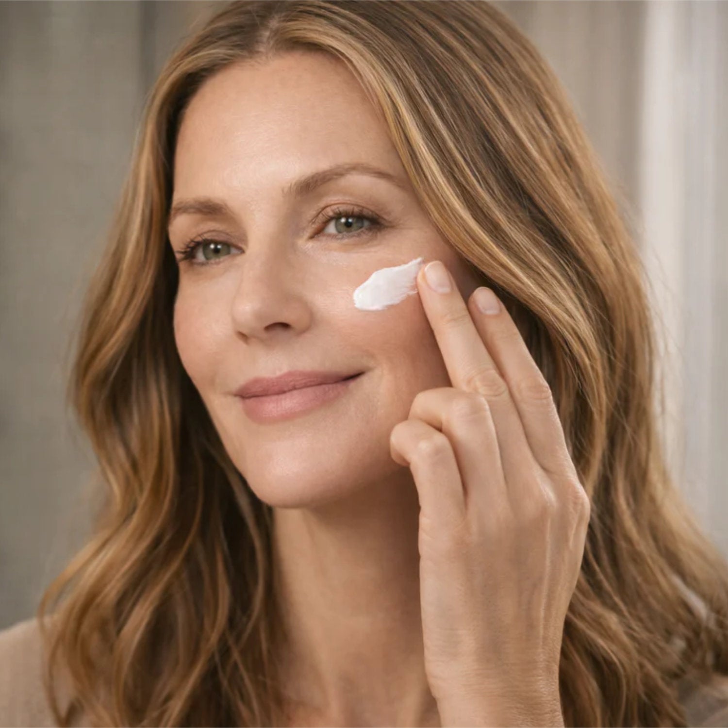 Frau mit Collagen Vegan Lifting Tagescreme, die sanft Creme auf Wange aufträgt, für strahlende Haut.