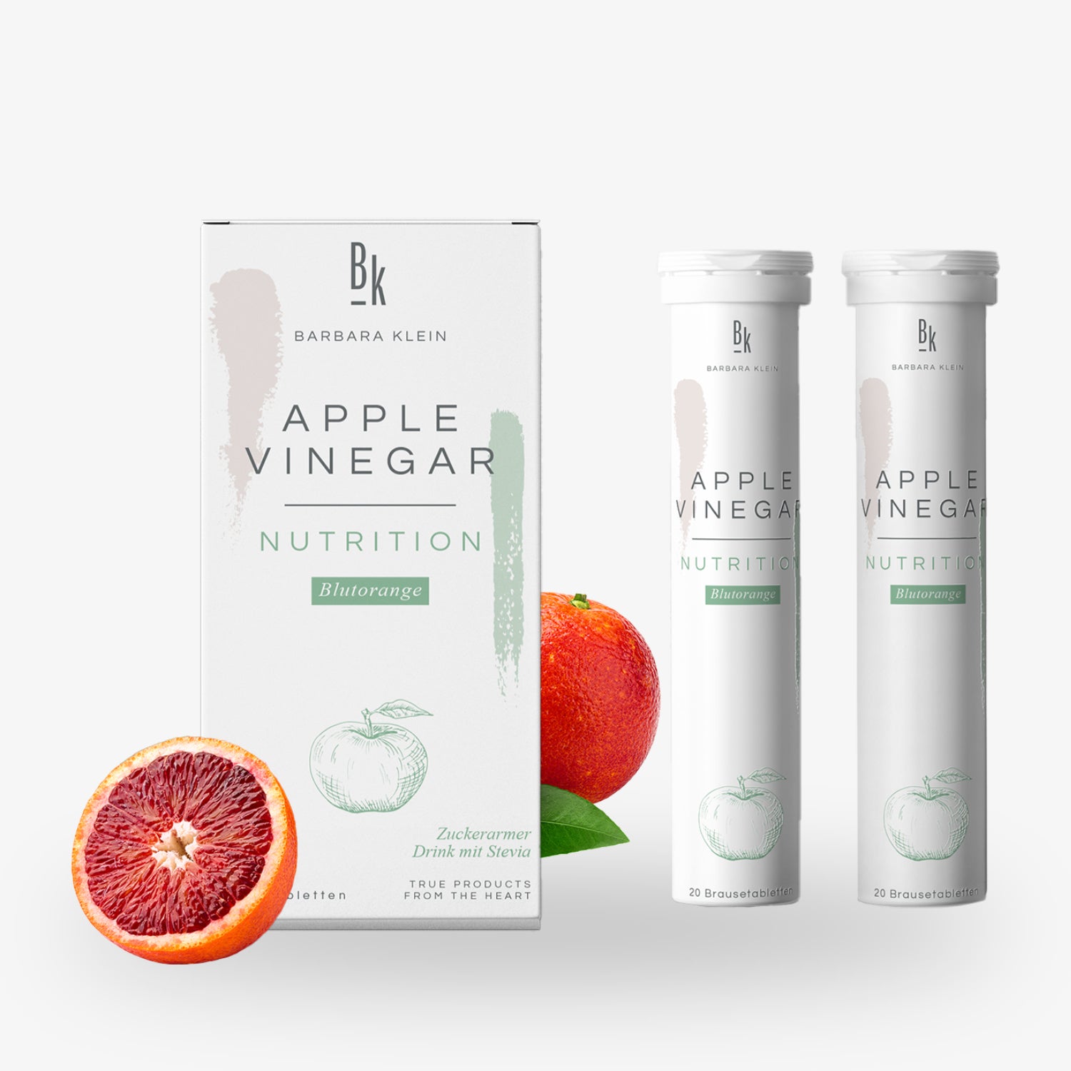 Verpackung von Apfelessig Nutrition Blutorange mit zwei Tuben und zwei Blutorangen im Hintergrund.