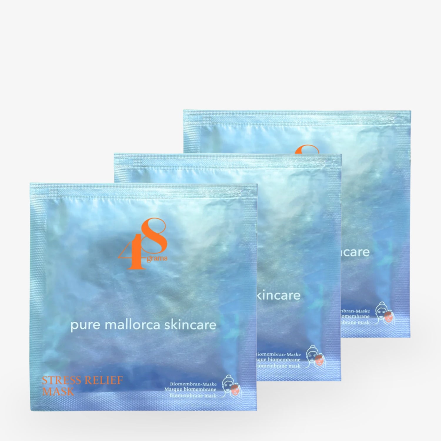 Drei blaue Verpackungen von "pure mallorca skincare" Stress Relief Masken mit orangefarbenem Logo und Text.