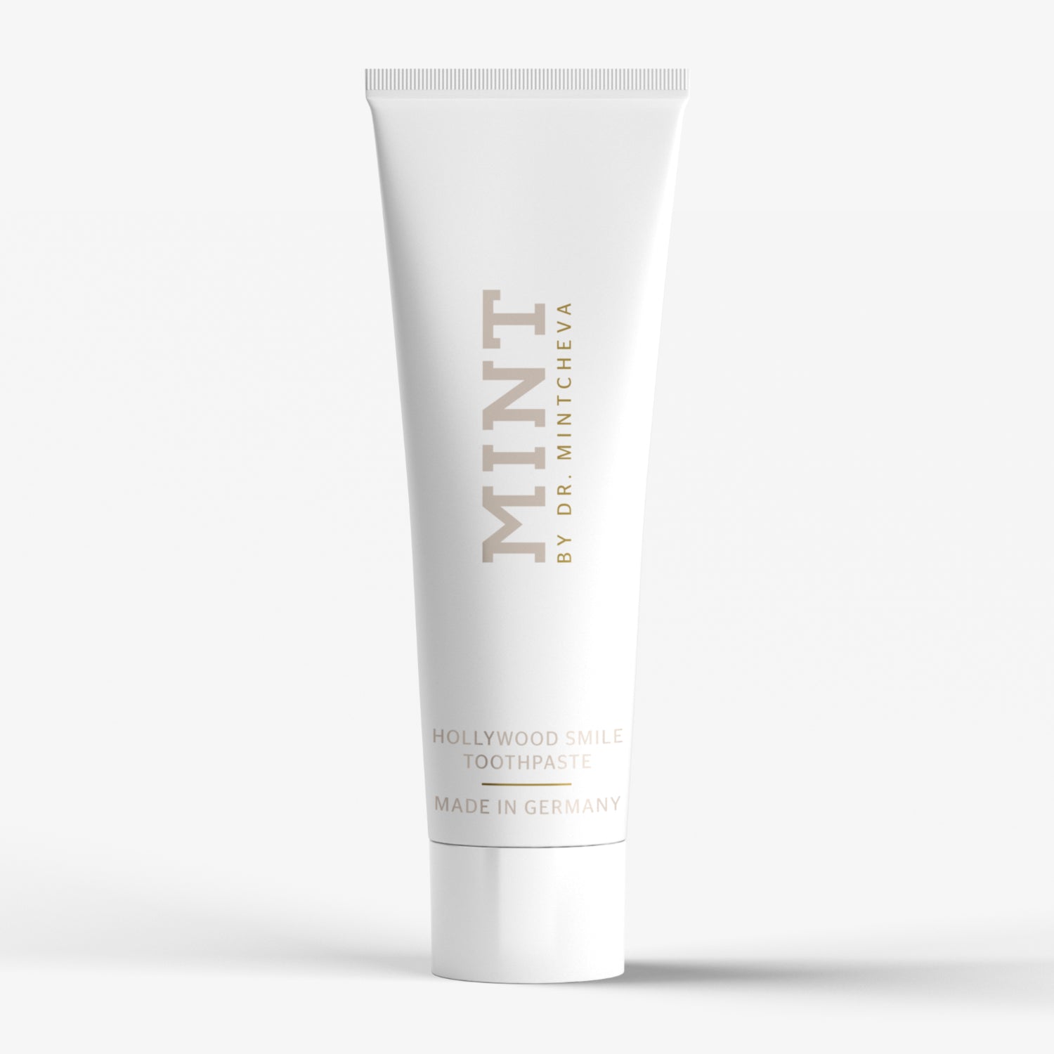 Weiße Zahnpastatube mit der Aufschrift "MINT BY DR. MINTCHEVA", "HOLLYWOOD SMILE TOOTHPASTE" und "MADE IN GERMANY".