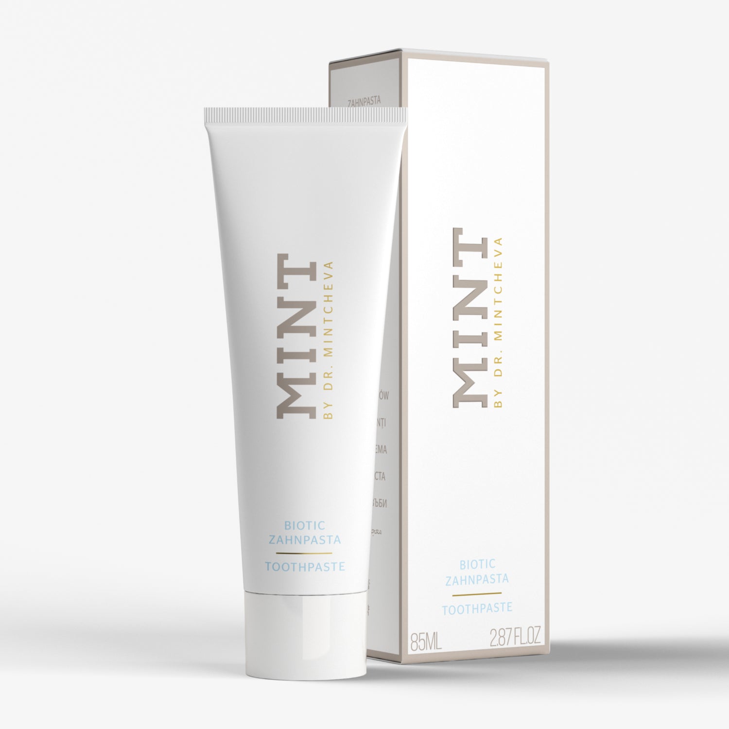 Weiße Zahnpastatube mit der Aufschrift "MINT" neben passender Verpackung, auf hellem Hintergrund.
