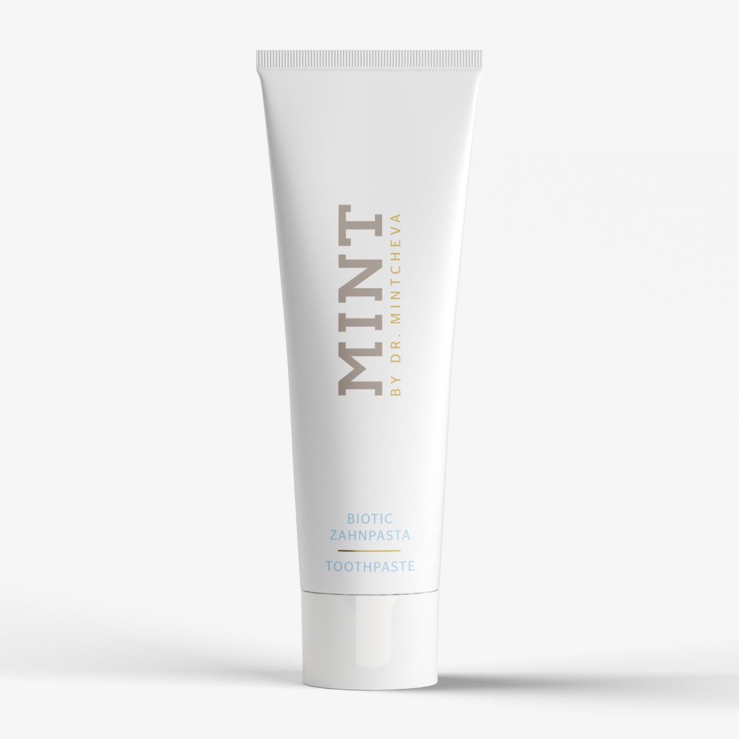 Weiße Zahnpastatube mit der Aufschrift "MINT BY DR. MINTCHEVA" auf hellem Hintergrund.