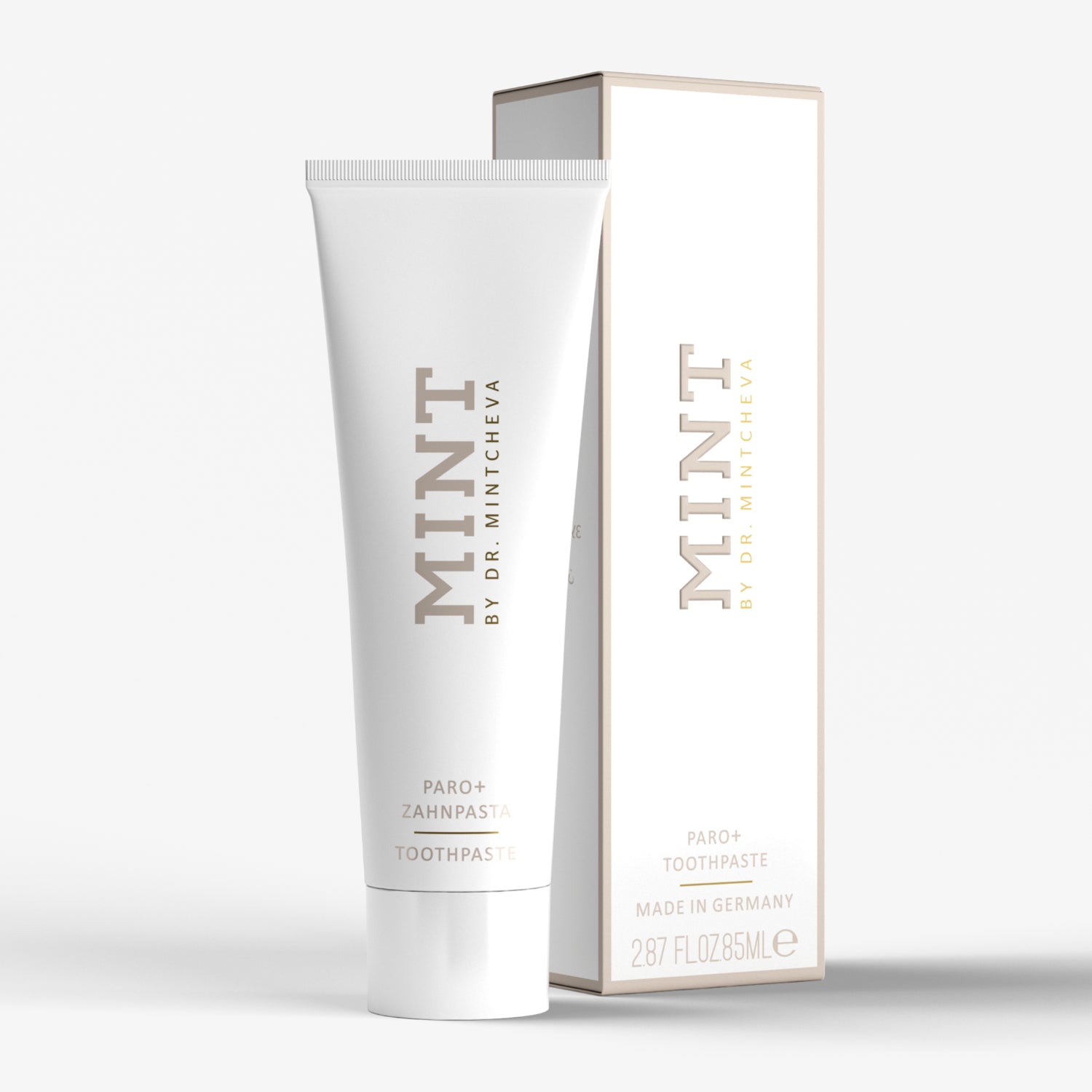 Weiße Zahnpastatube mit der Aufschrift "MINT BY DR. MINTCHEVA" neben passender Verpackung.