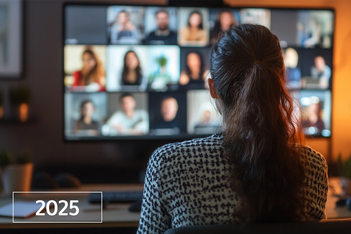 Eine Frau betrachtet 2025 einen Bildschirm mit einem Videoanruf, mehrere Personen scheinen teilzunehmen.