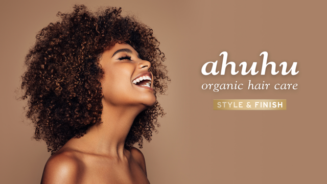 Frau mit lockigem Haar, lächelnd vor braunem Hintergrund, neben dem Schriftzug "ahuhu organic hair care, STYLE & FINISH".