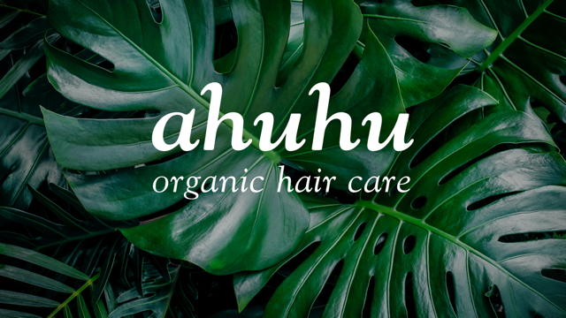 Große grüne Monstera-Blätter im Hintergrund mit dem Text "ahuhu organic hair care" in Weiß darüber.