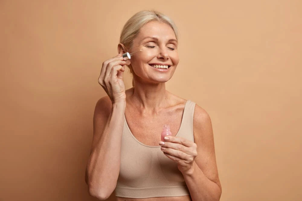 Frau mit Retinol-Serum, lächelnd, Anti-Aging-Hautpflege-Produkt, Hautpflege routine. Retinol: Der meistgesuchte Anti-Aging-Wirkstoff – was er wirklich kann.