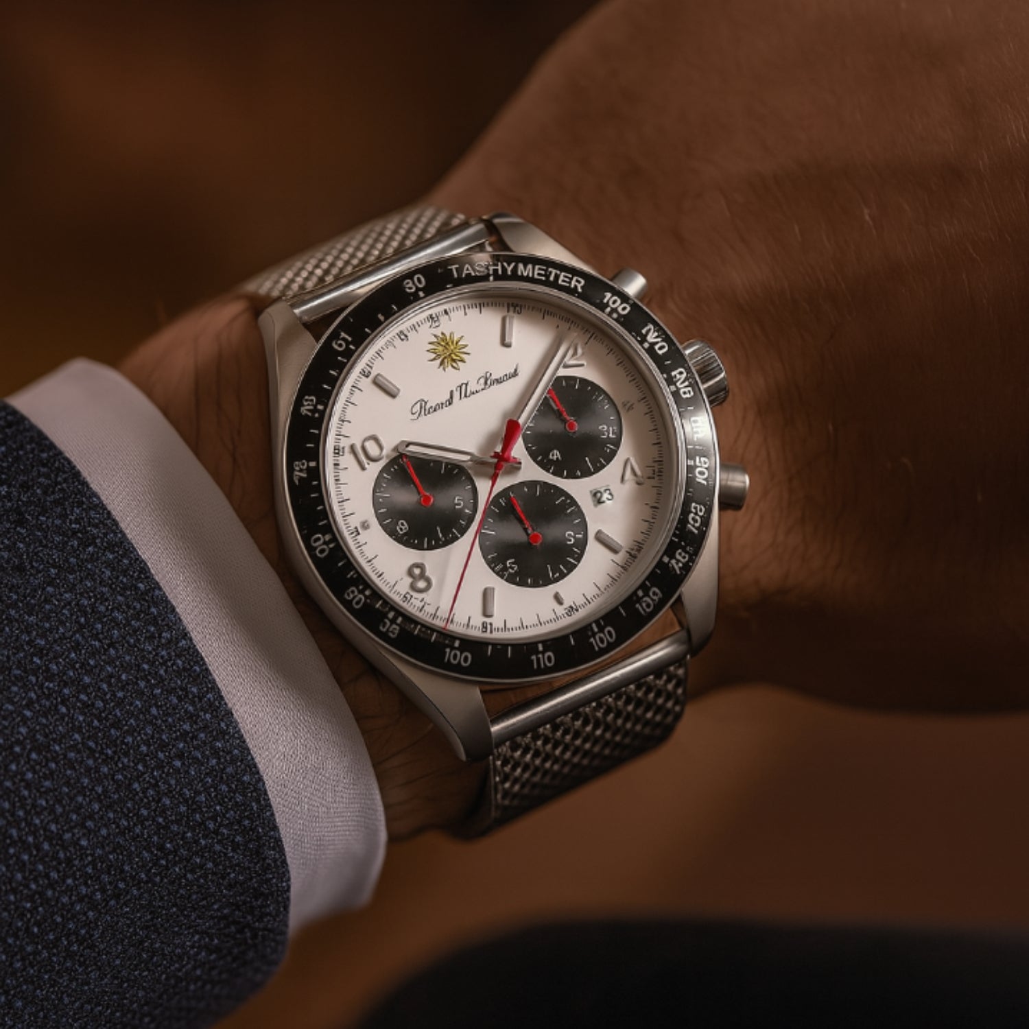 Nahaufnahme einer Armbanduhr mit silbernem Gehäuse, weißem Zifferblatt und schwarzem Lederarmband an einem Handgelenk.