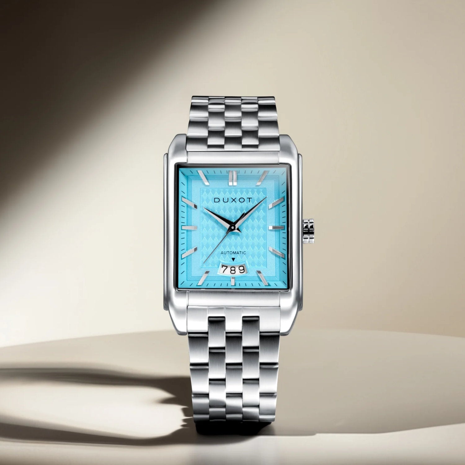 Automatikuhr DUXOT mit quadratischem Gehäuse und türkisfarbener Zifferblattgestaltung auf silbernem Armband