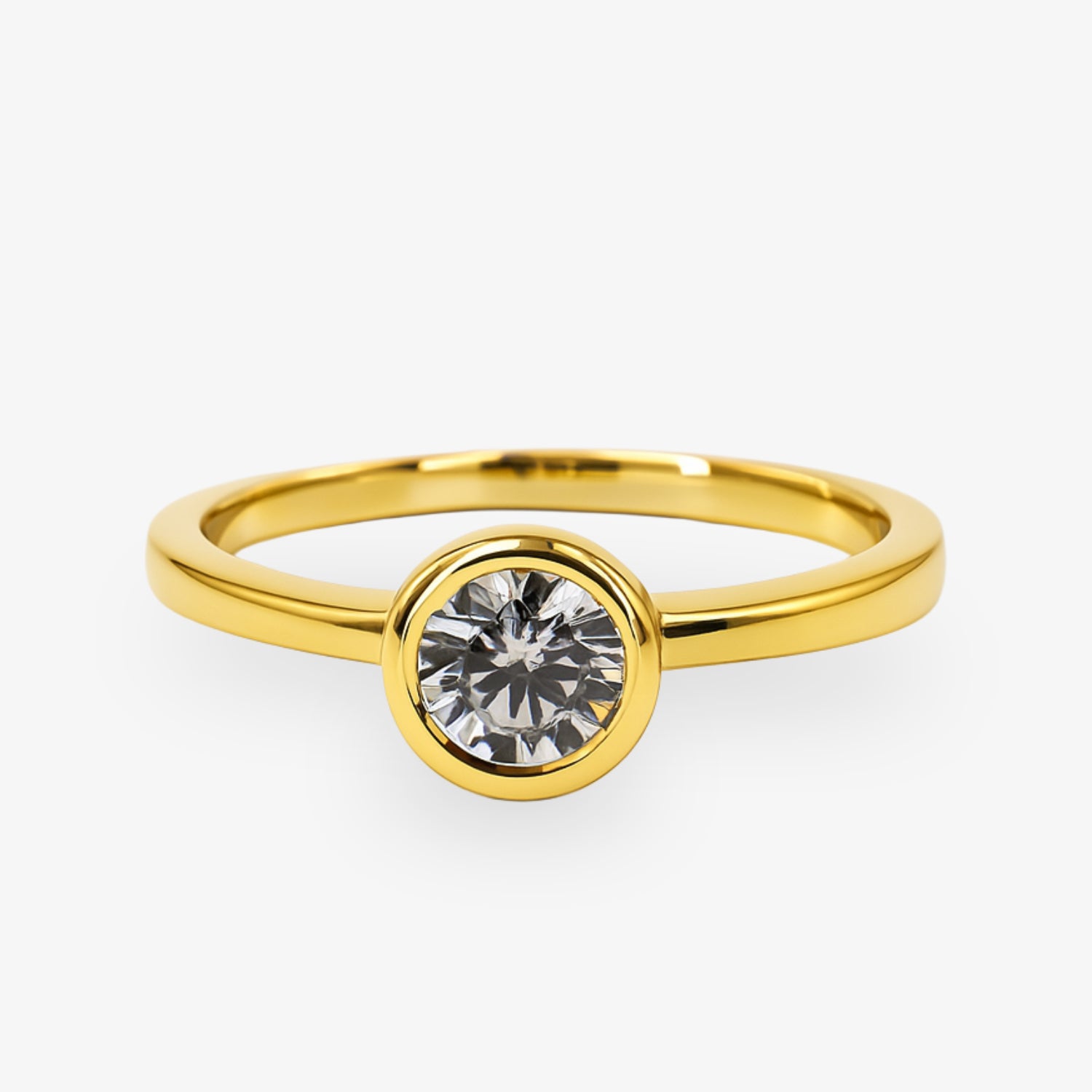 Goldener Ring mit einem einzelnen großen Diamanten in einer runden Fassung auf einem weißen Hintergrund.