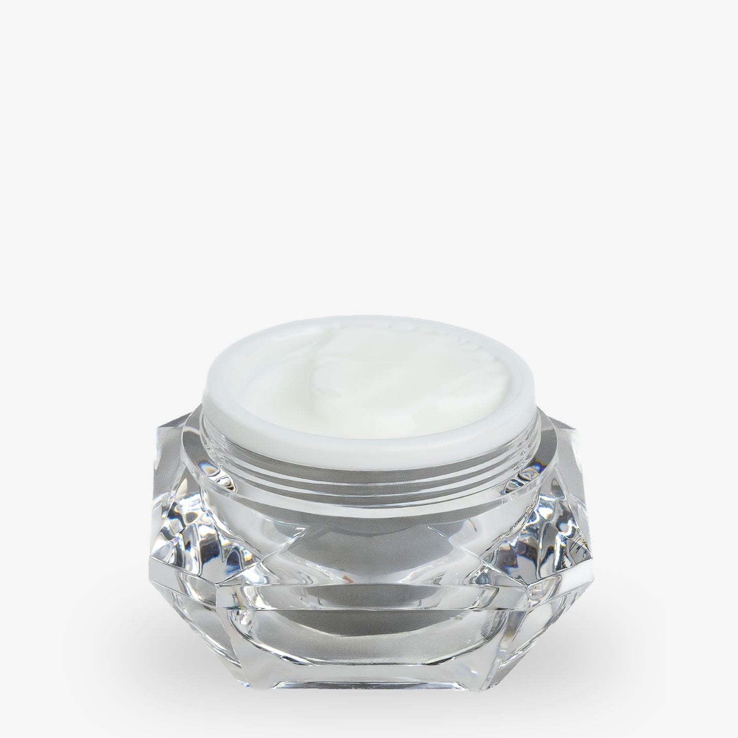 Ein geöffneter Tiegel mit weißer Creme, in einem transparenten, facettierten Behälter.
