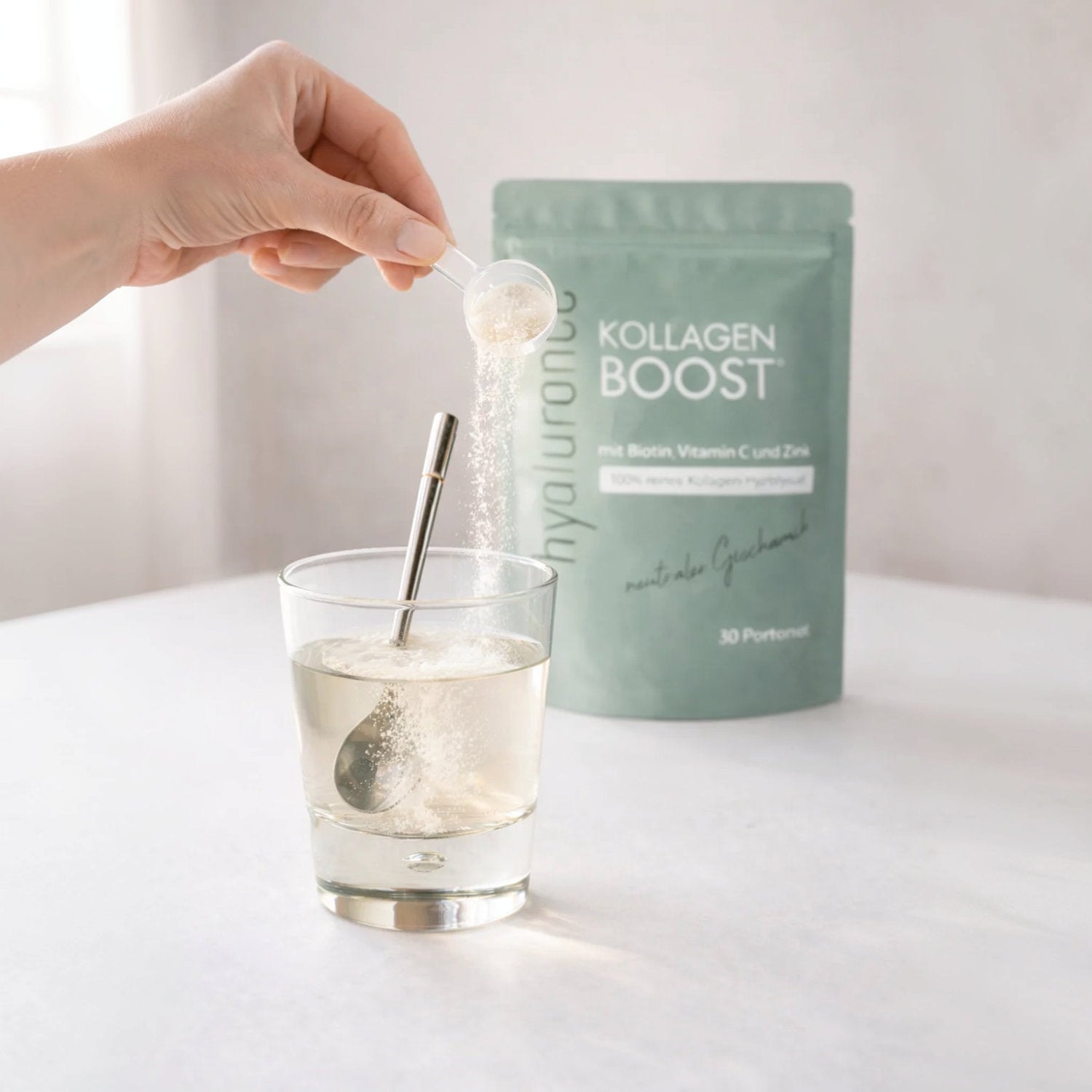 Kollagen Boost Pulver 30 Tage - 300 g wird in ein Glas Wasser gegeben, um eine nahrhafte Mischung zu erstellen.