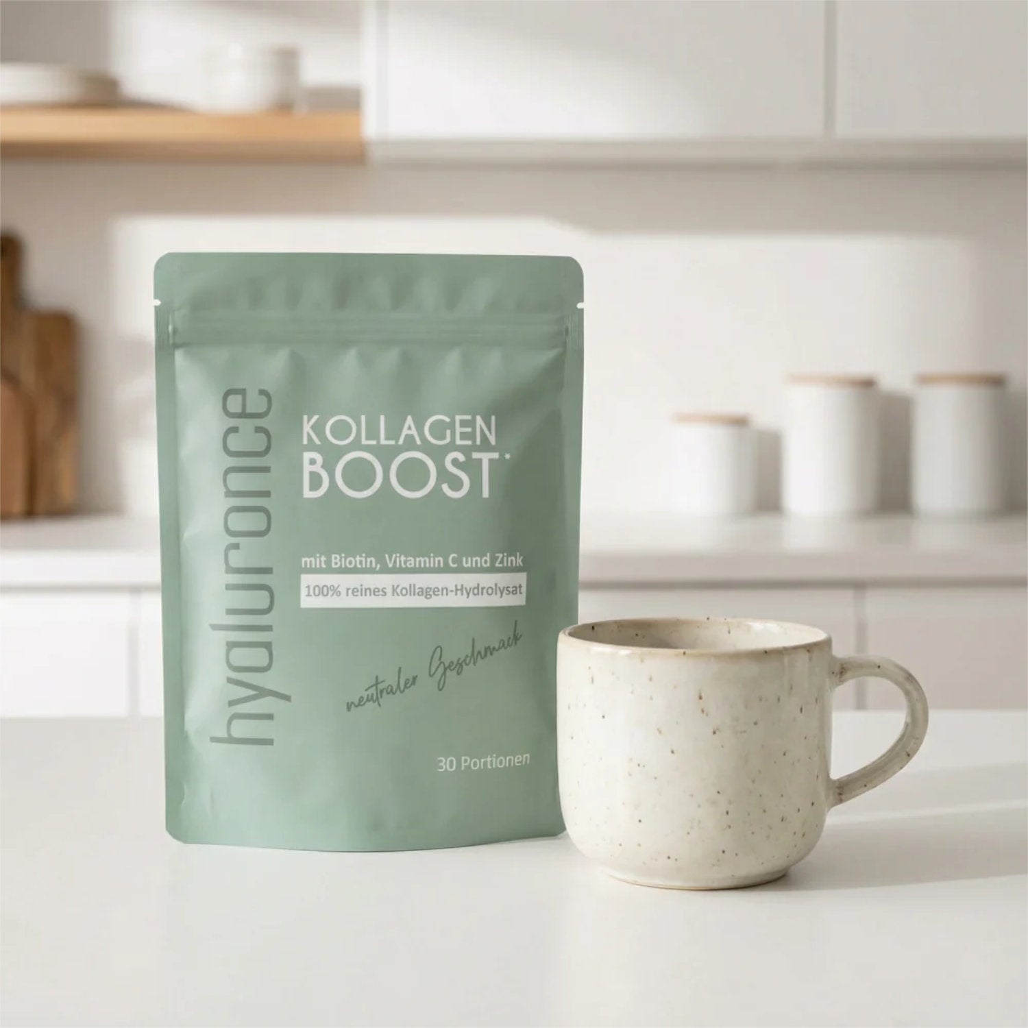 Kollagen Boost Pulver 30 Tage - 300 g in schöner Verpackung neben einer Tasse, mit Biotin, Vitamin C und Zink.