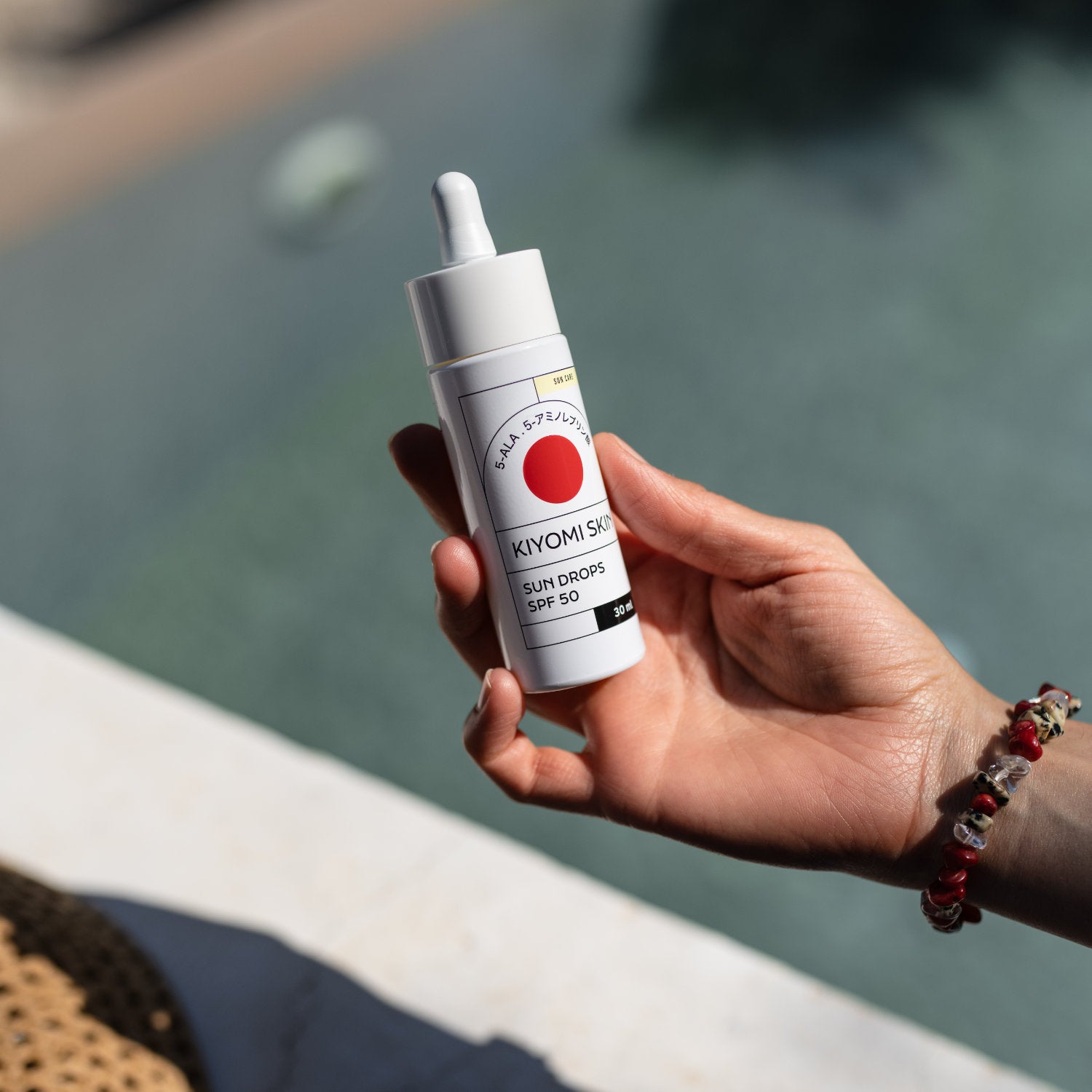 Person hält das Sonnenserum Sun Drops SPF 50 - ideales Produkt zum Schutz empfindlicher Haut.