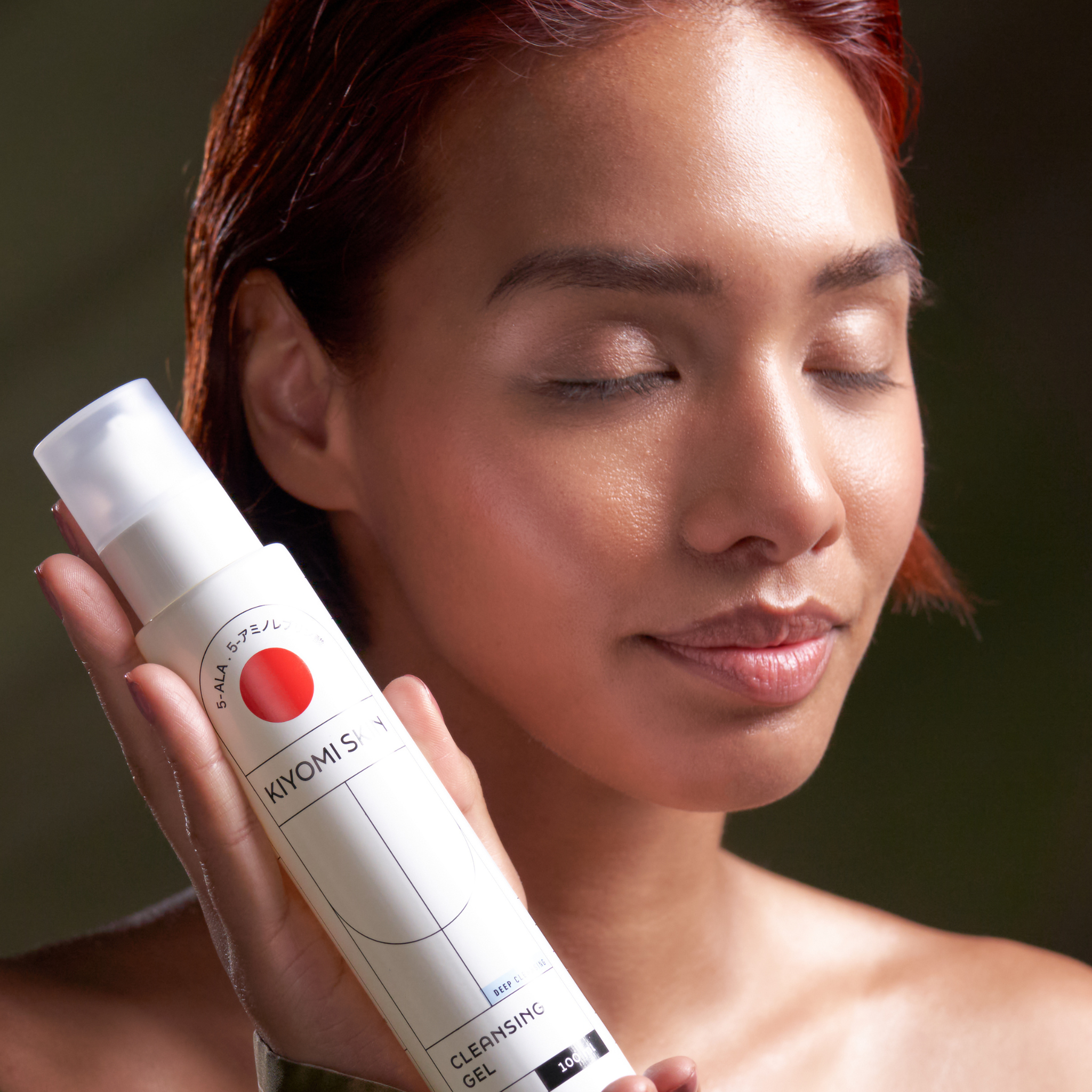 Frau mit geschlossenen Augen hält KIYOMI SKIN Cleansing Gel, Teil des Glass Skin Starter Duo Pflegesets.