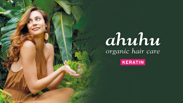 Frau in braunem Kleid sitzt im Grünen neben Text "ahuhu organic hair care KERATIN".